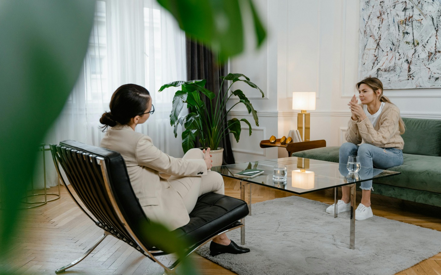 
        Kobieta rozmawia z terapeutą w przytulnym wnętrzu.
    