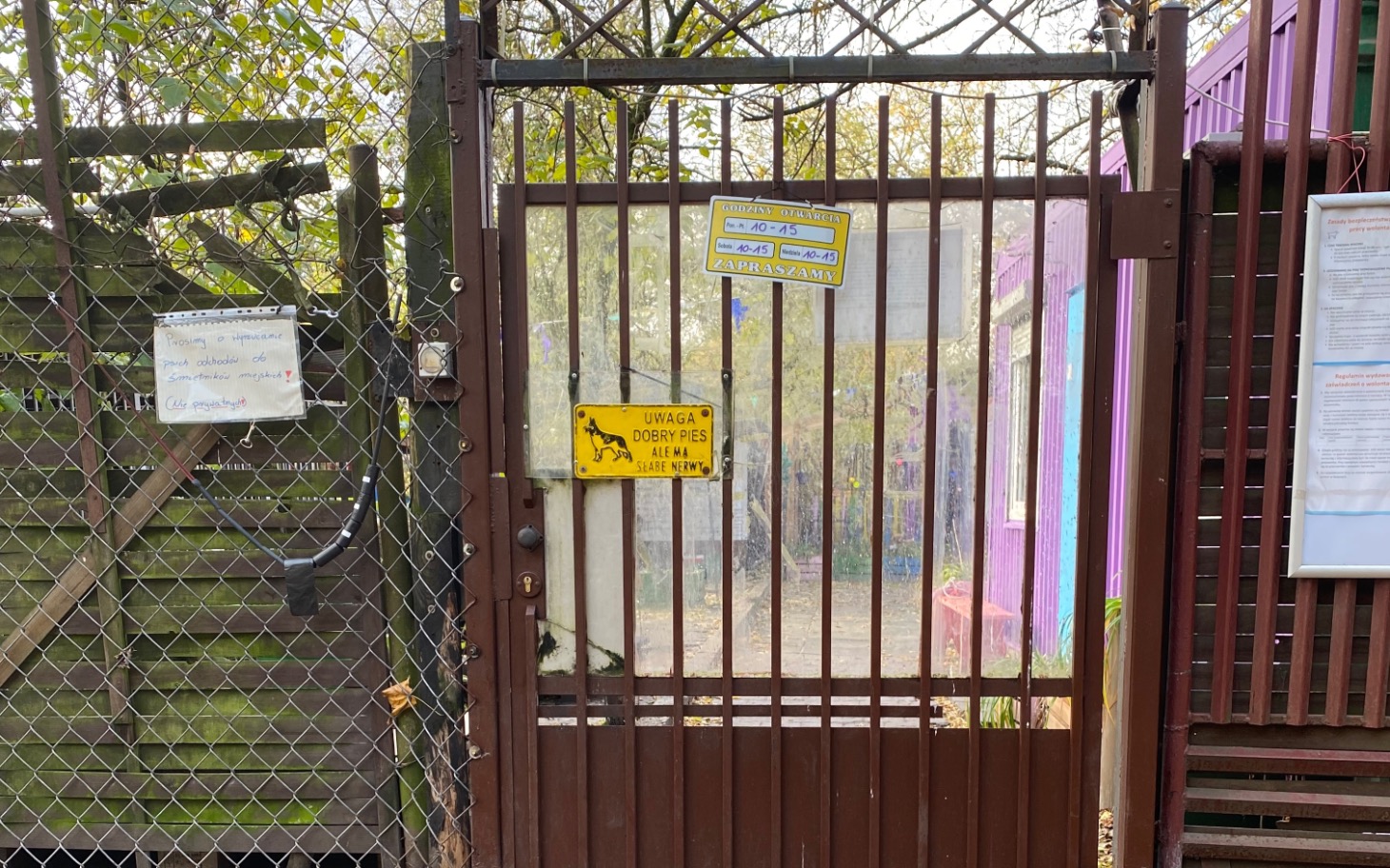 
        Zamknięta brama z ostrzeżeniem o psach.
    
