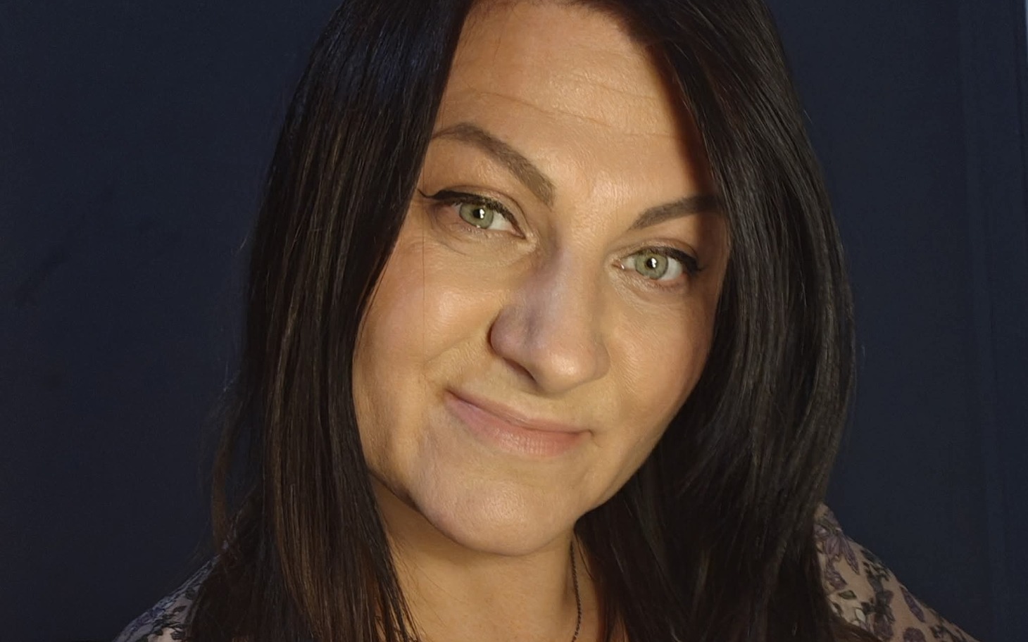 
        Portret kobiety z długimi włosami, uśmiechającej się do kamery.
    