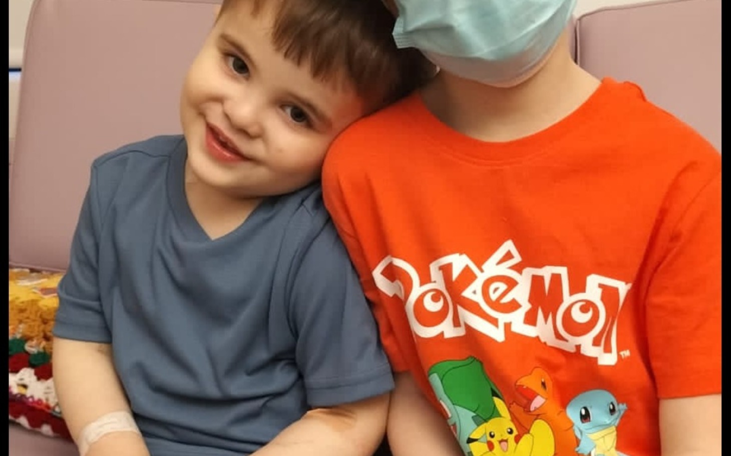 
        Dzieci przytulające się w szpitalu, jedno w koszulce Pokémon.
    