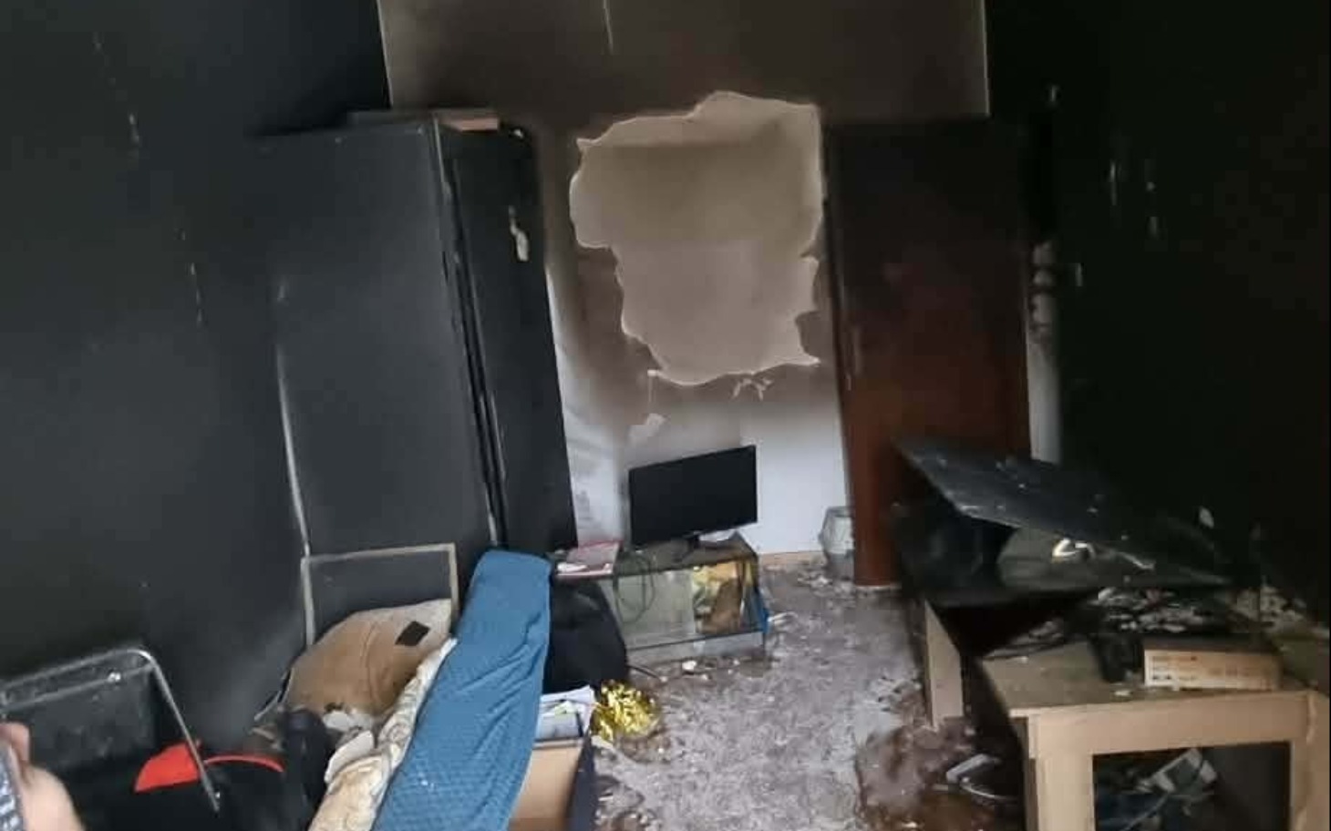 
        Zniszczone wnętrze mieszkania po pożarze, pokazujące dramatyczne skutki.
    