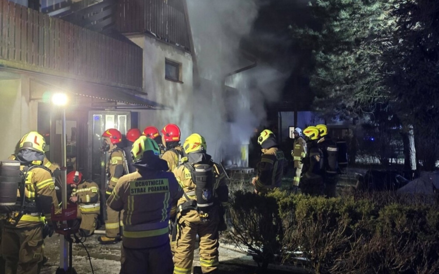 
        Strażacy w akcji, gaszący pożar w budynku.
    