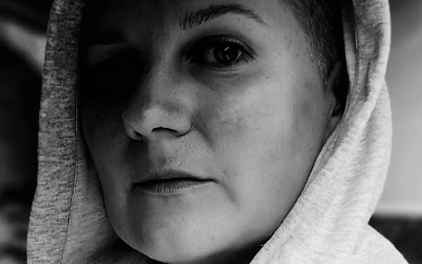 
        Czarnobiałe zdjęcie kobiety w kapturze.
    