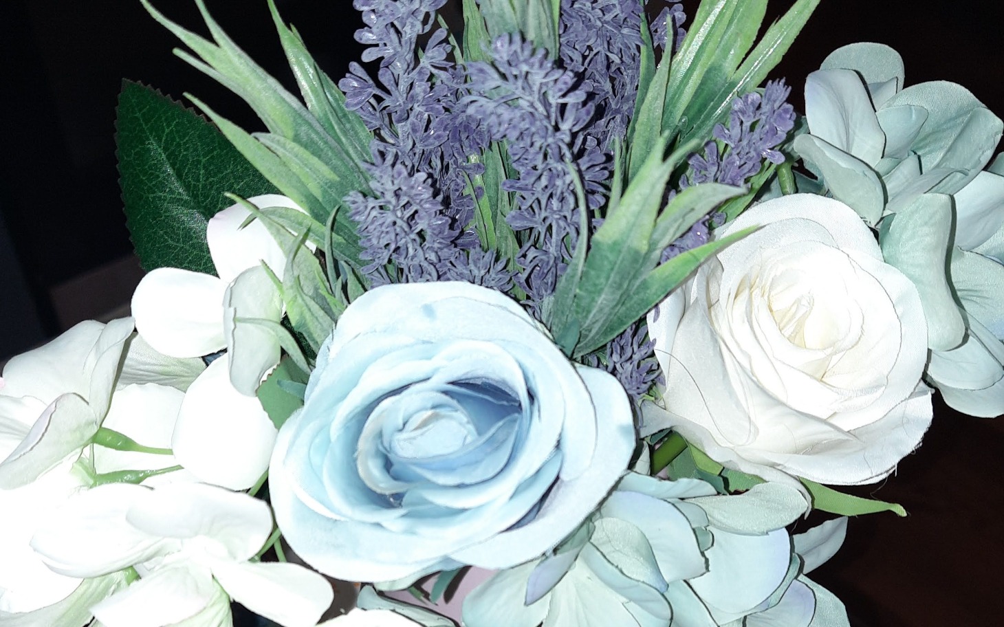 
        Bukiet sztucznych kwiatów w odcieniach bieli i fioletu.
    