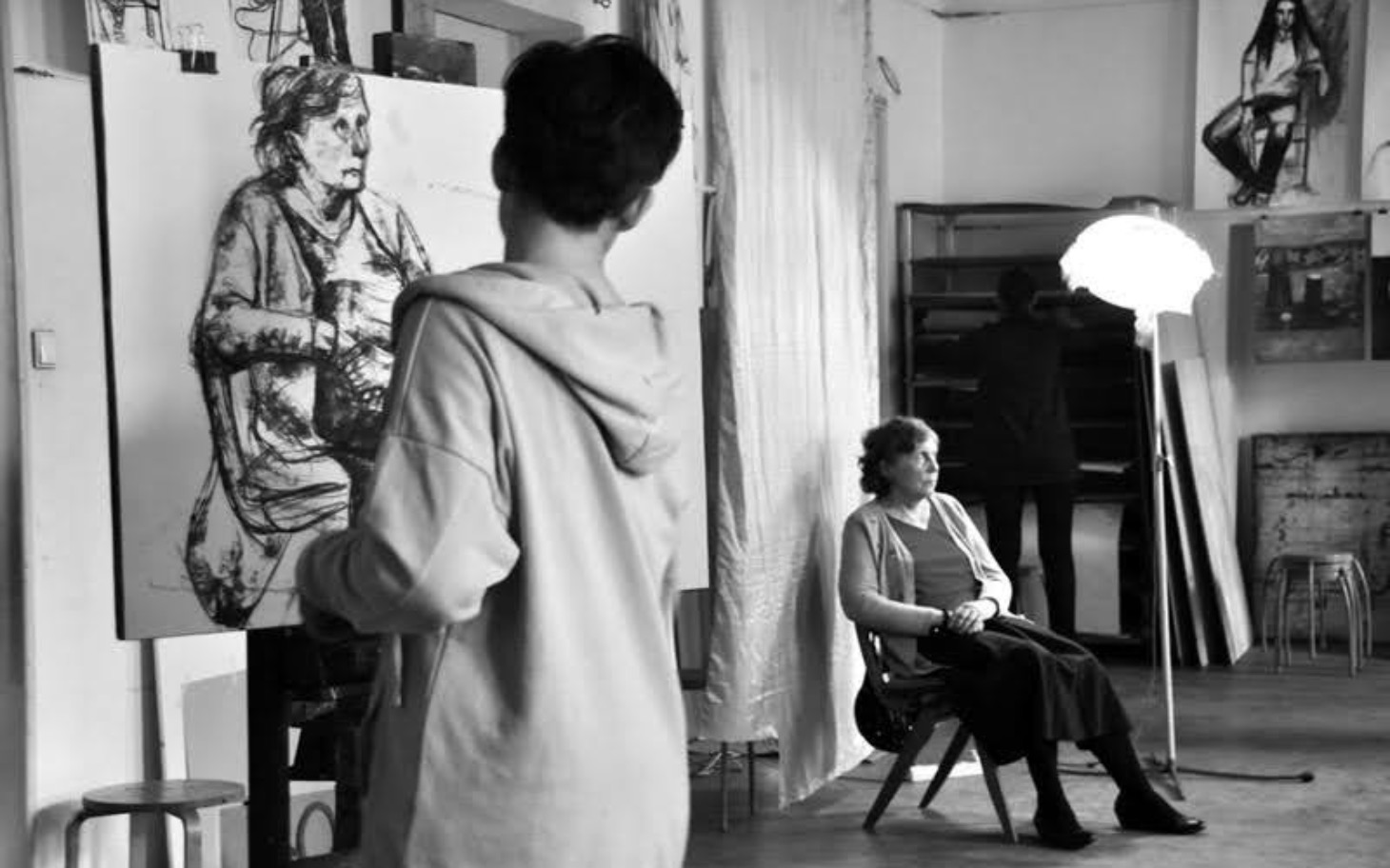 
        Artysta malujący portret kobiety w pracowni artystycznej.
    