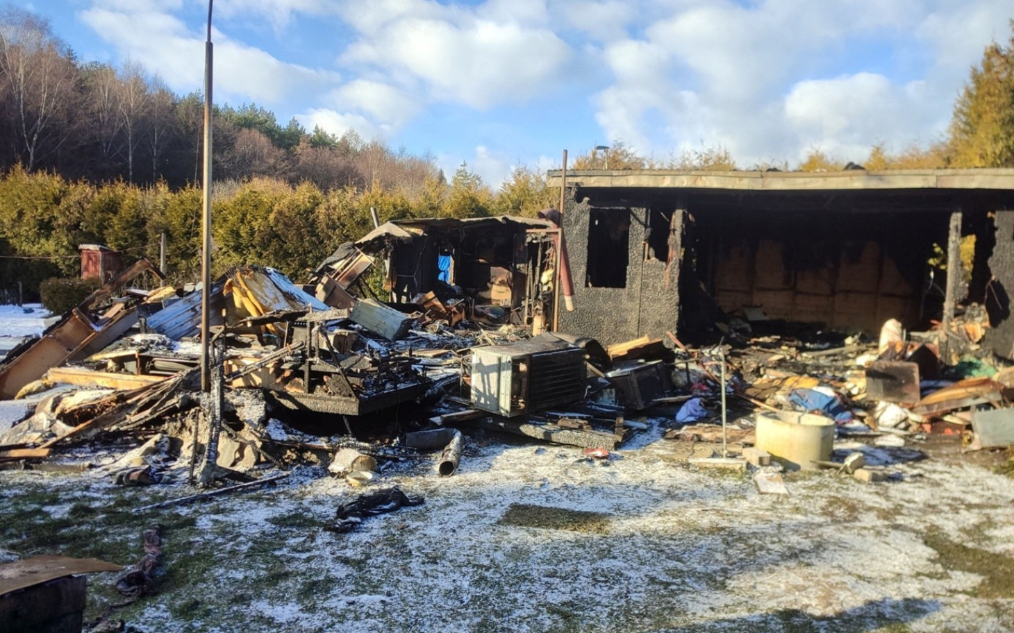 
        Zniszczony budynek po pożarze, z gruzem i odpadkami.
    