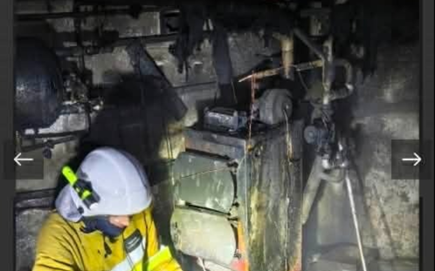 
        Strażak pracujący w trudnych warunkach, otoczony przez ciemność.
    