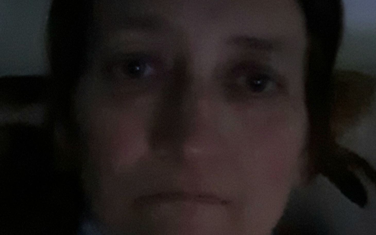 Portret osoby z wyraźnym smutkiem na twarzy.