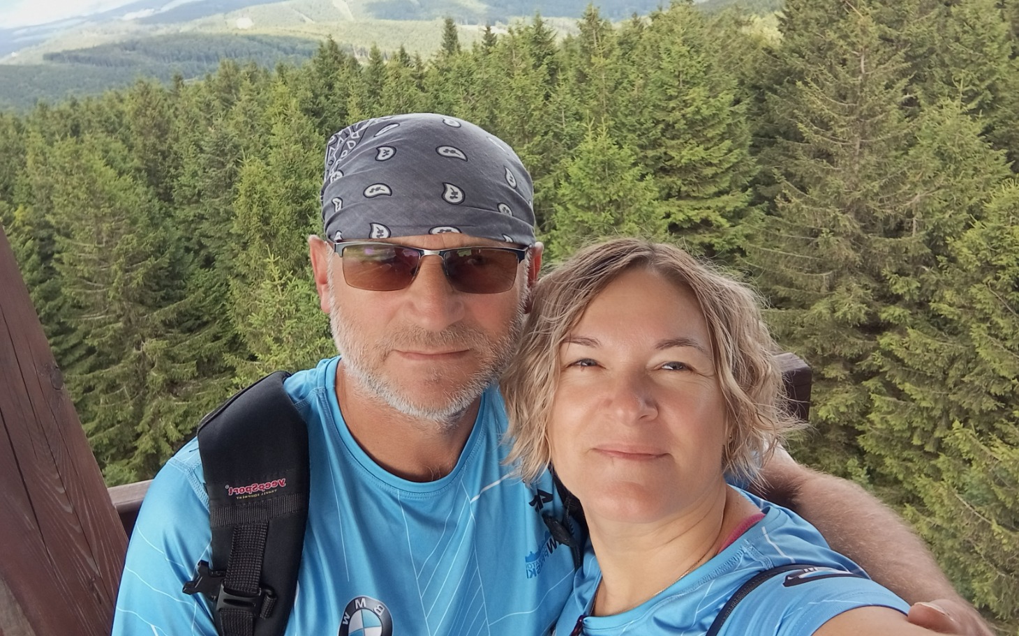 
        Para na szczycie góry, otoczona lasem.
    