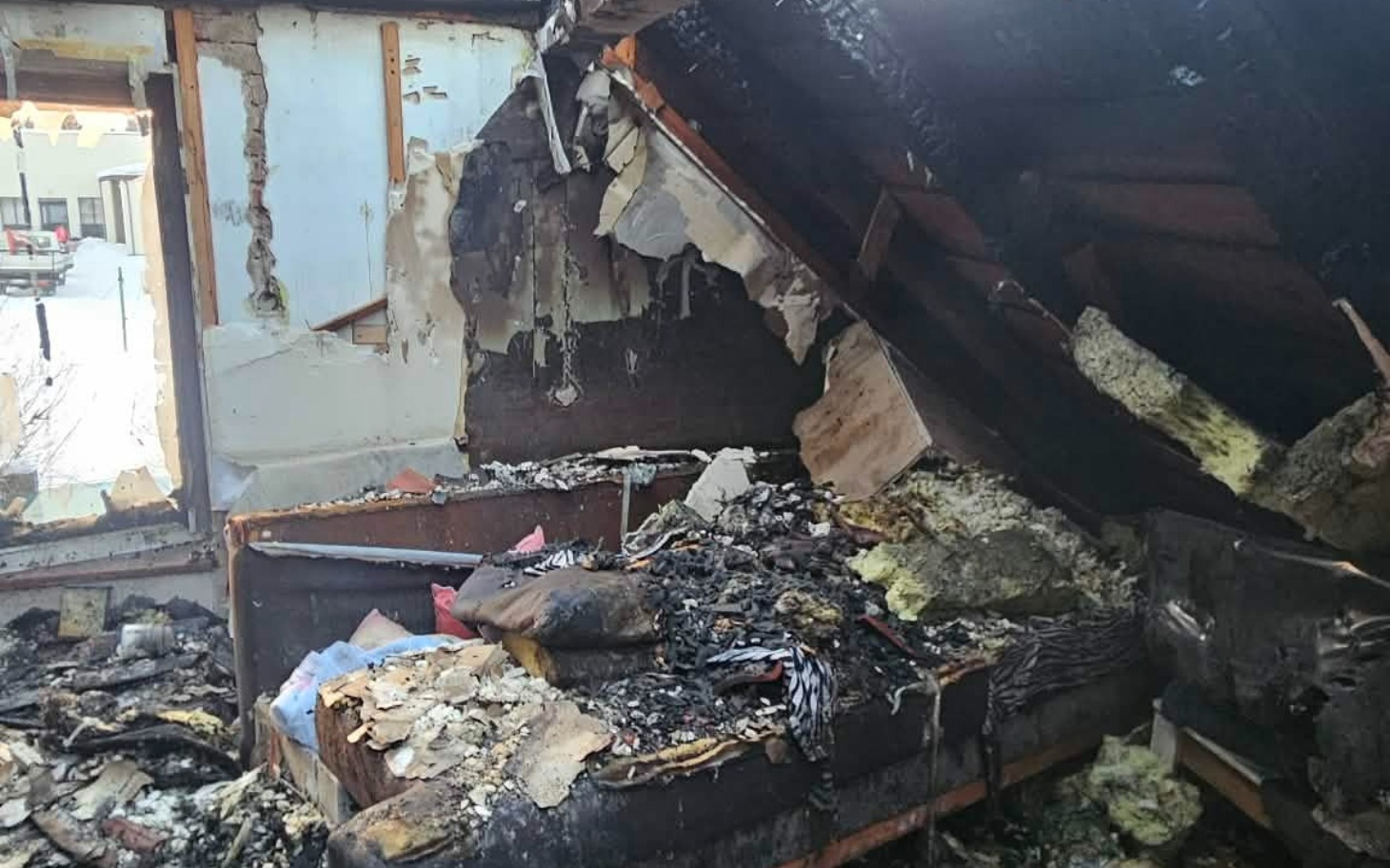 
        Zniszczone poddasze po pożarze, z gruzem i odpadkami.
    