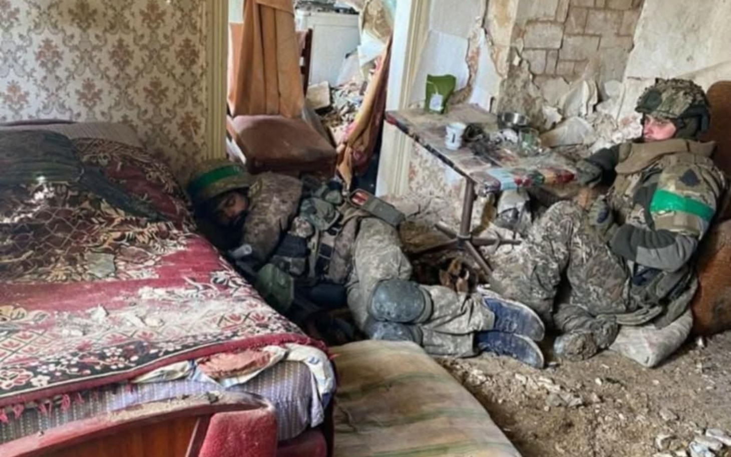 
        Żołnierze odpoczywający w zniszczonym pomieszczeniu.
    