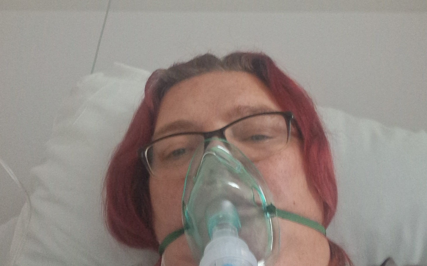 
        Kobieta w szpitalu z maską tlenową, potrzebująca wsparcia.
    
