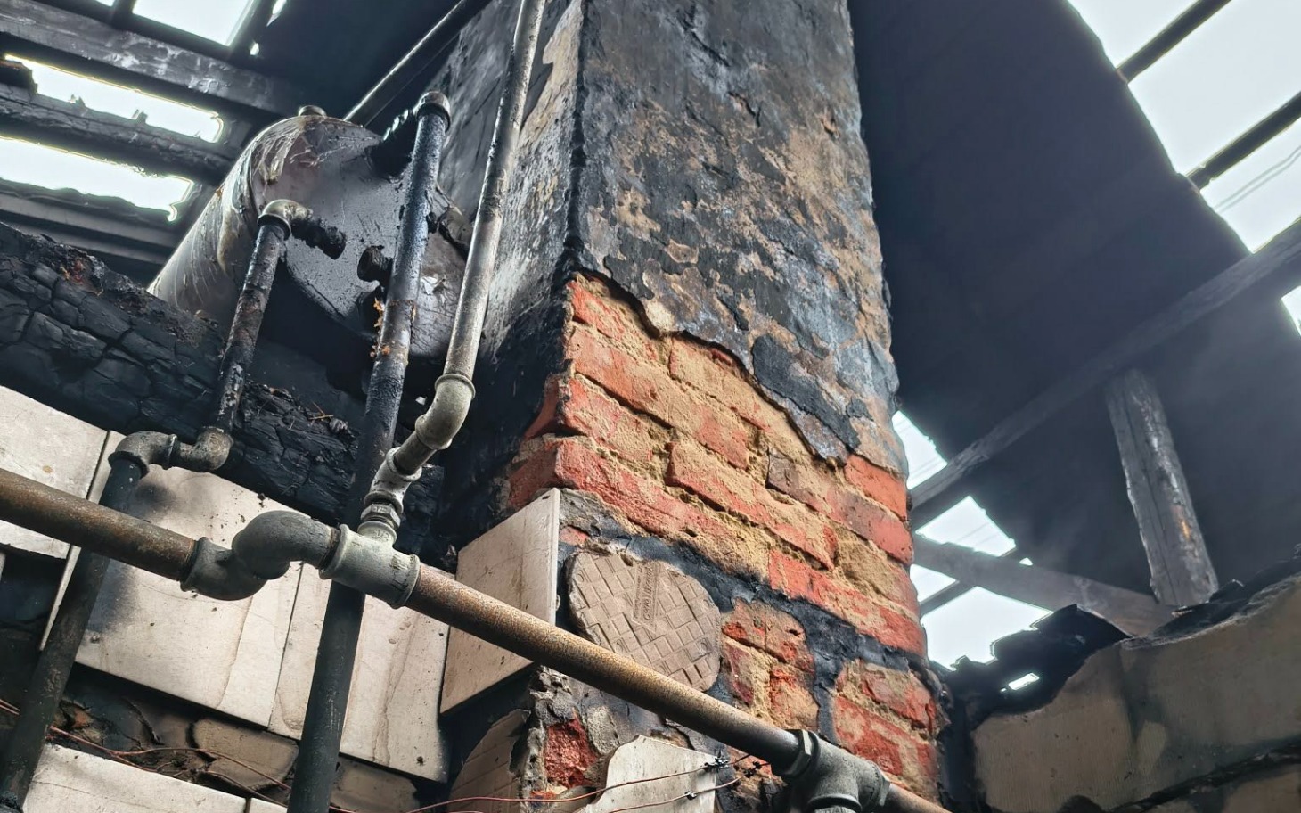 
        Zniszczony komin w budynku po pożarze.
    