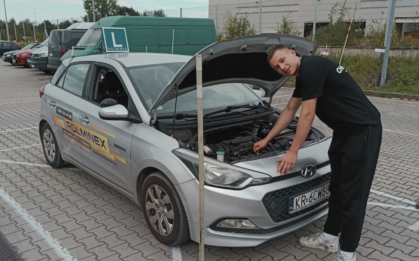 
        Młody mężczyzna przy samochodzie, uczący się naprawy.
    