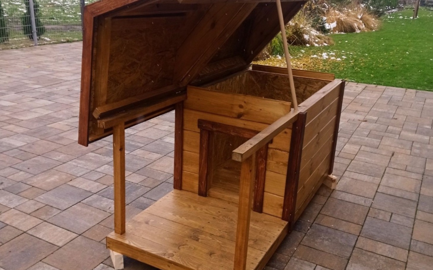 
        Drewniana buda dla zwierząt, gotowa do użytku na świeżym powietrzu.
    