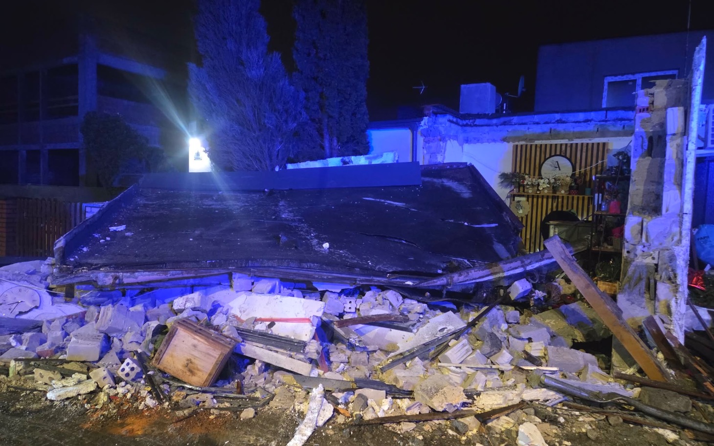 
        Zniszczony budynek po zawaleniu, gruz wszędzie.
    