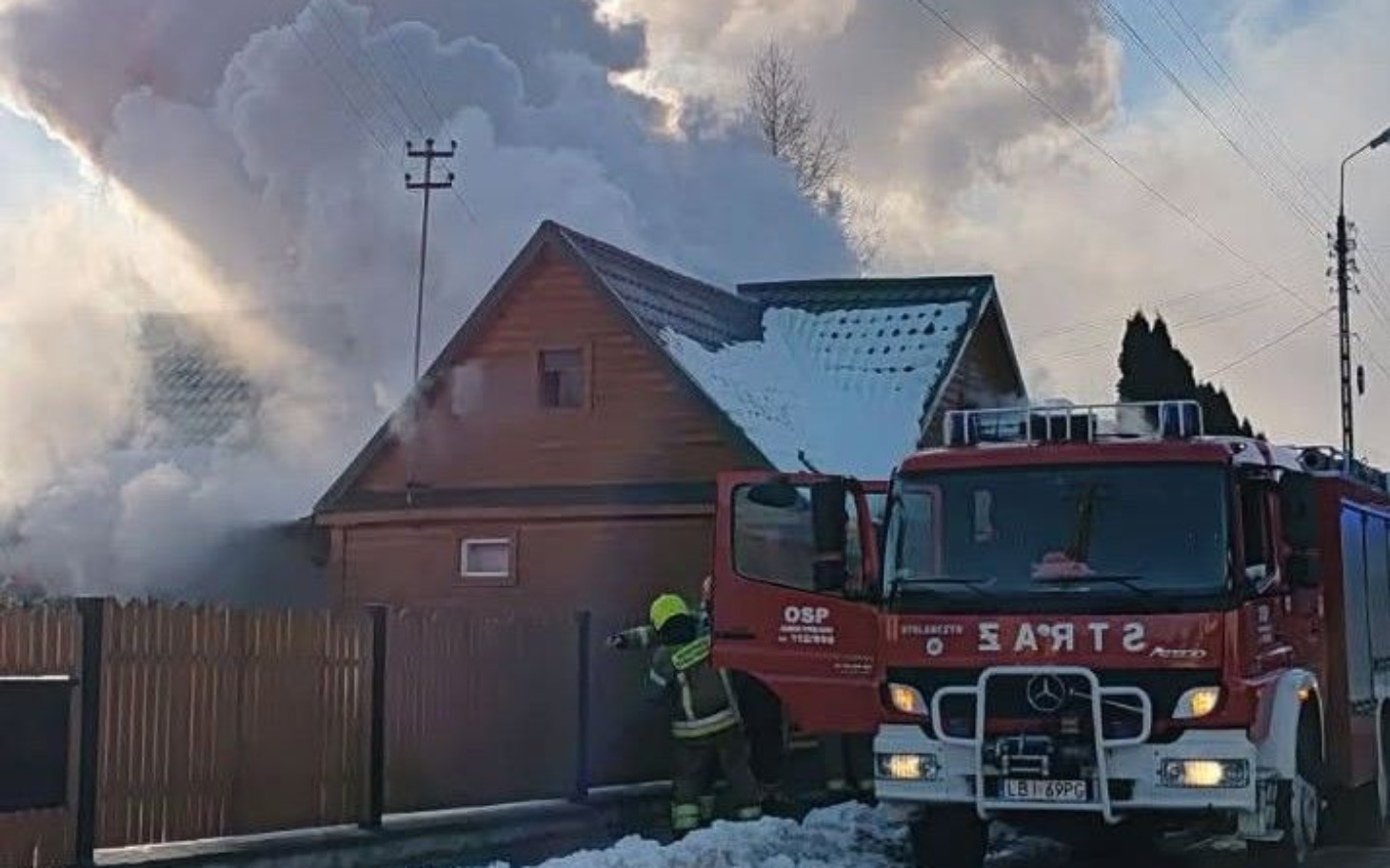 
        Strażak gasi pożar w domku jednorodzinnym.
    