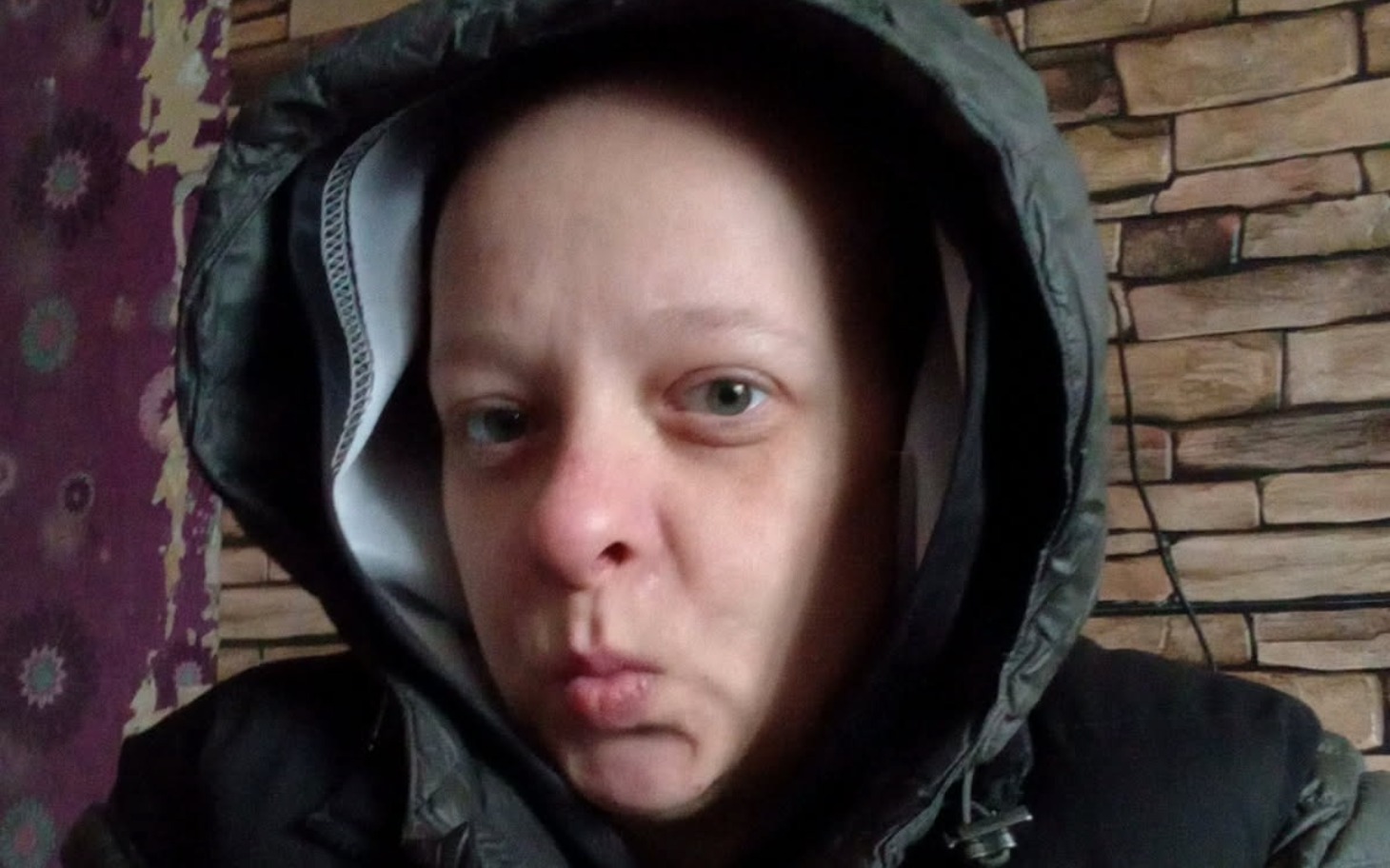 
        Kobieta w kapturze z wyrazem twarzy.
    