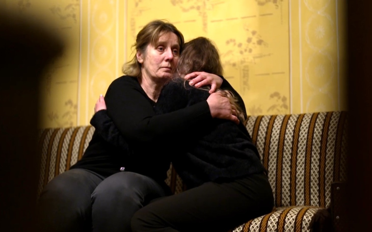 
        Kobieta przytula dziewczynkę, obie wyglądają na zmartwione.
    