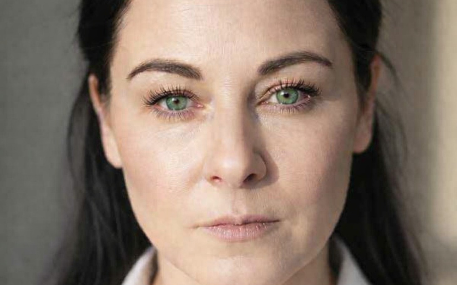 
        Portret kobiety z wyrazistymi zielonymi oczami.
    