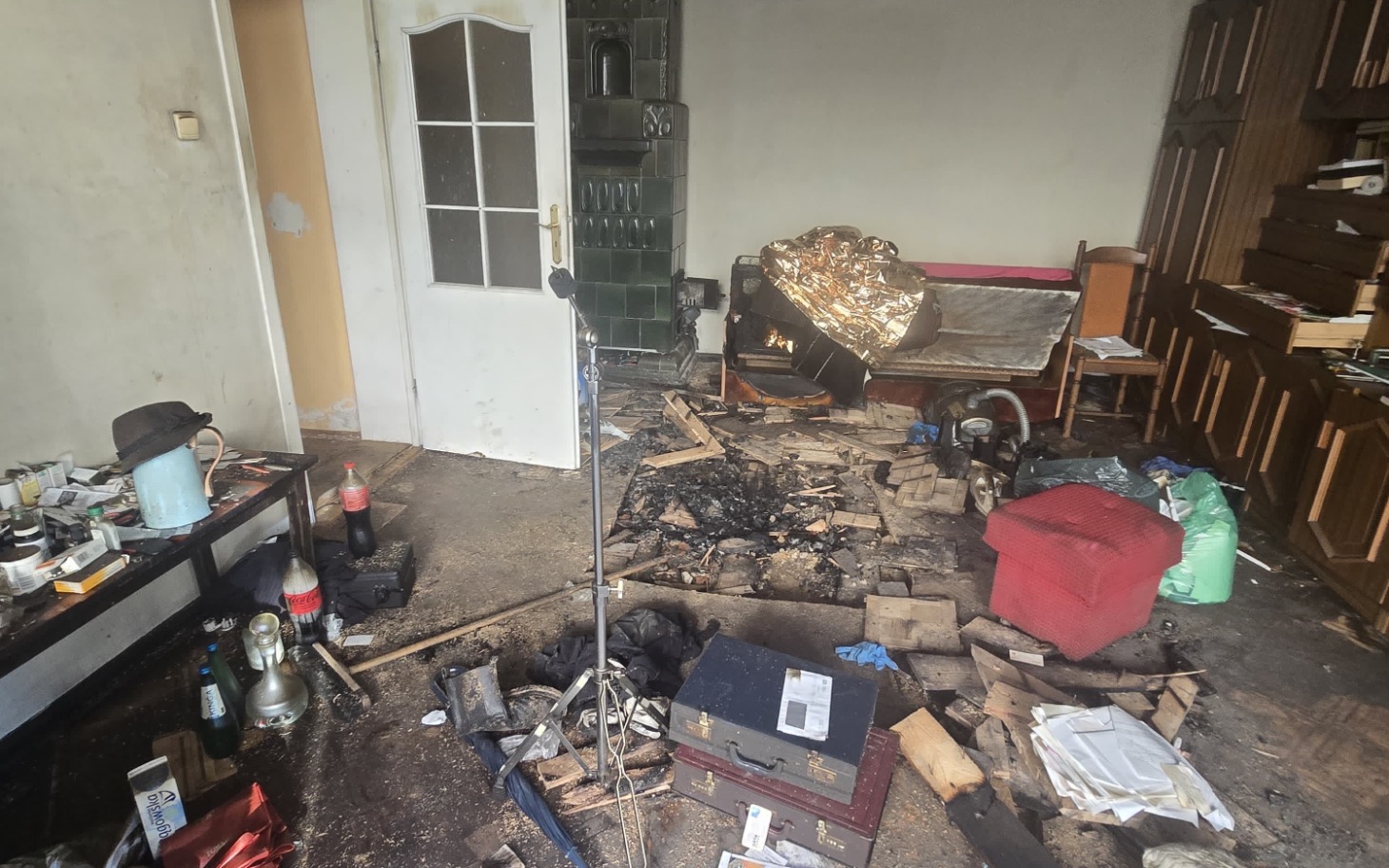 
        Zniszczone wnętrze po pożarze, z bałaganem i zniszczeniami.
    