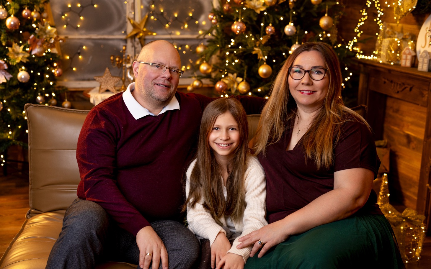 
        Rodzina pozująca na tle świątecznych dekoracji.
    