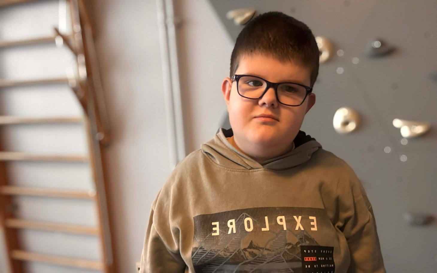 
        Chłopiec w okularach, patrzący w obiektyw.
    