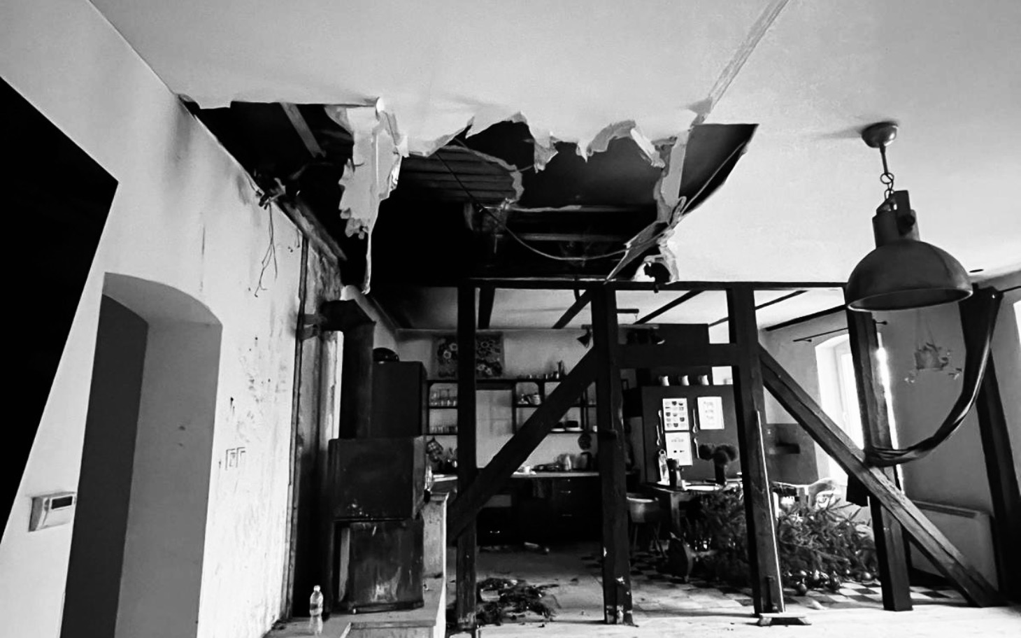 
        Zniszczony sufit w pomieszczeniu, z widocznymi uszkodzeniami.
    