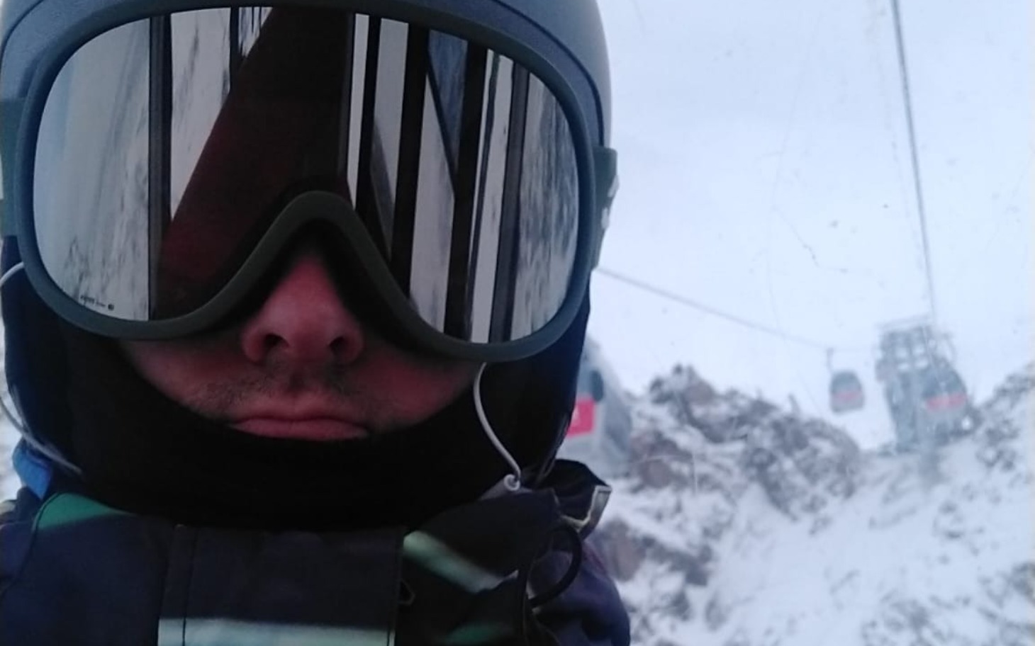 
        Mężczyzna w goglach narciarskich na stoku górskim.
    