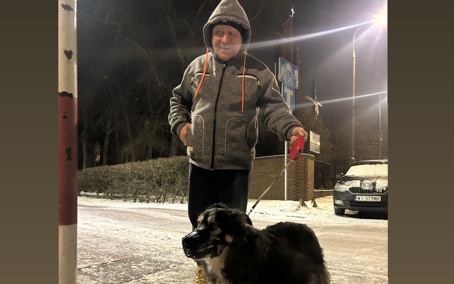 
        Mężczyzna spacerujący z psem w zimowej scenerii.
    