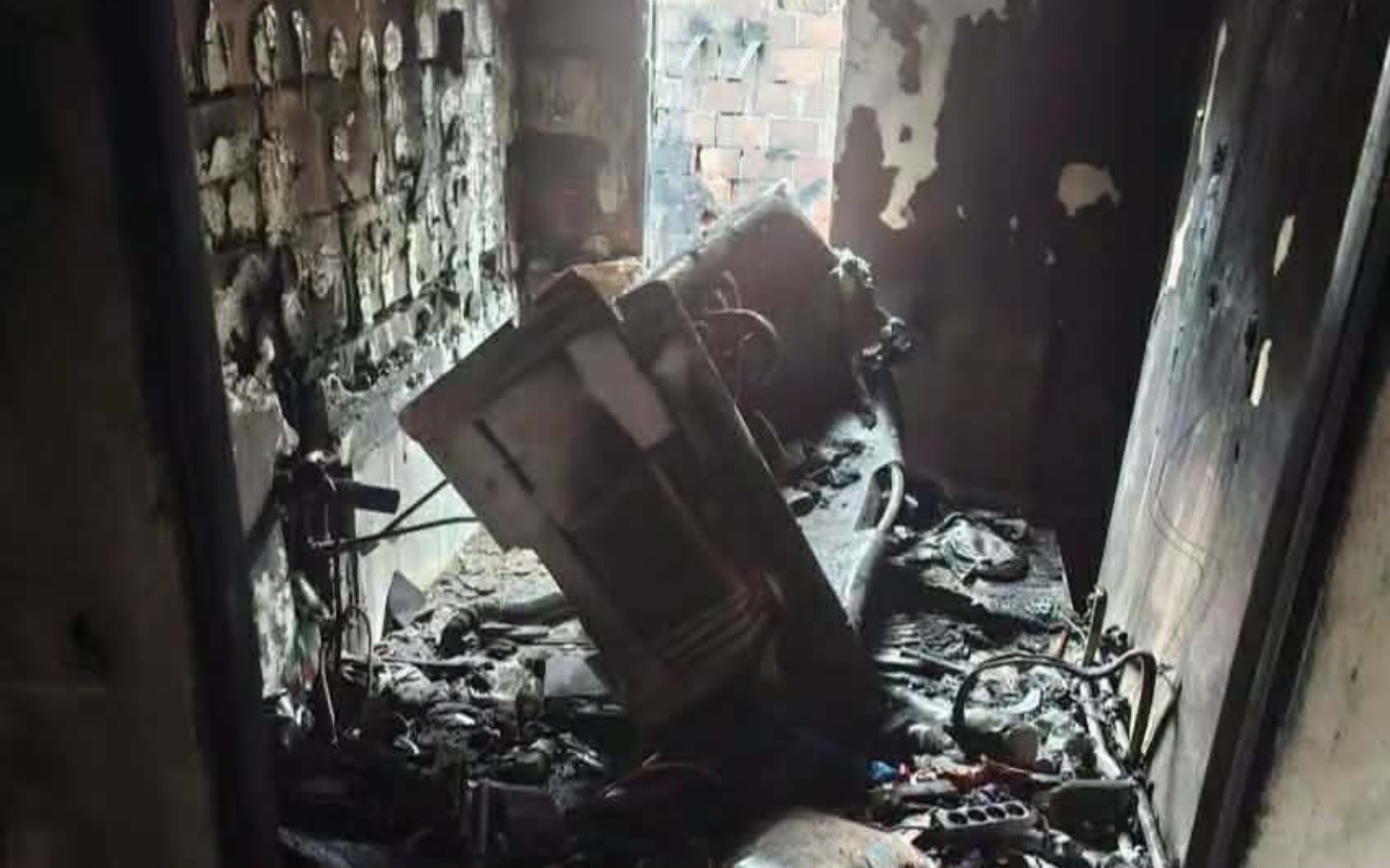 
        Zniszczony pokój po pożarze, z ruinami sprzętu.
    