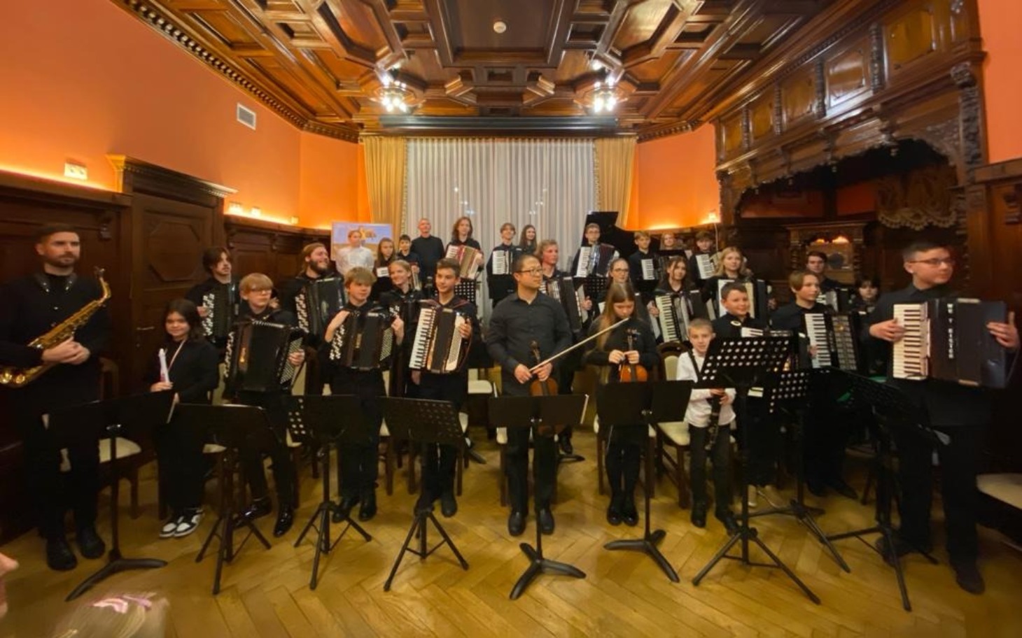 
        Grupa muzyków grających na akordeonach w eleganckim wnętrzu.
    