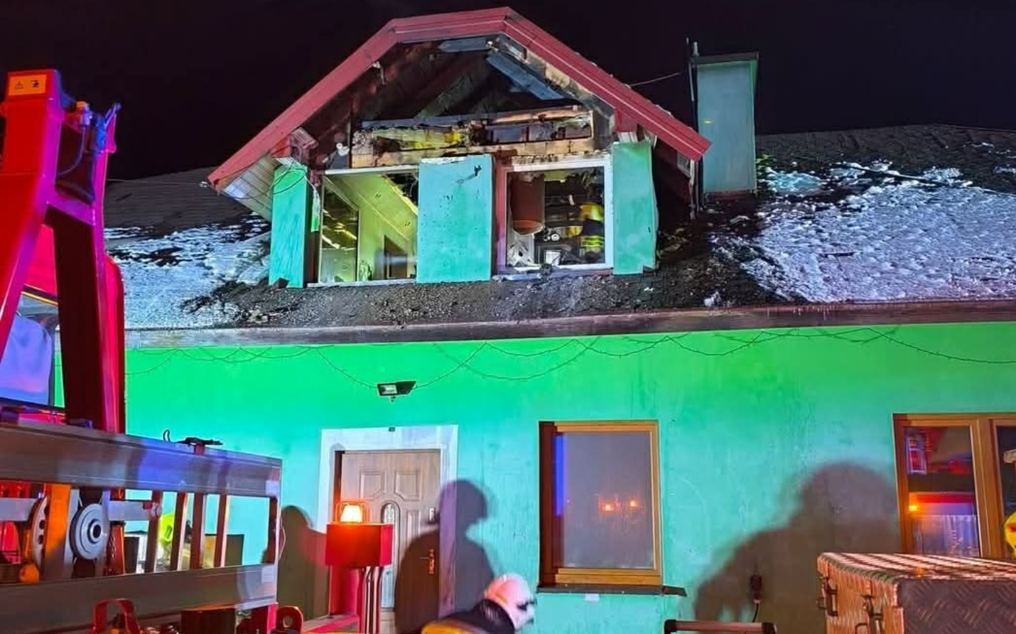 
        Zniszczony dach budynku po pożarze, widoczne uszkodzenia.
    