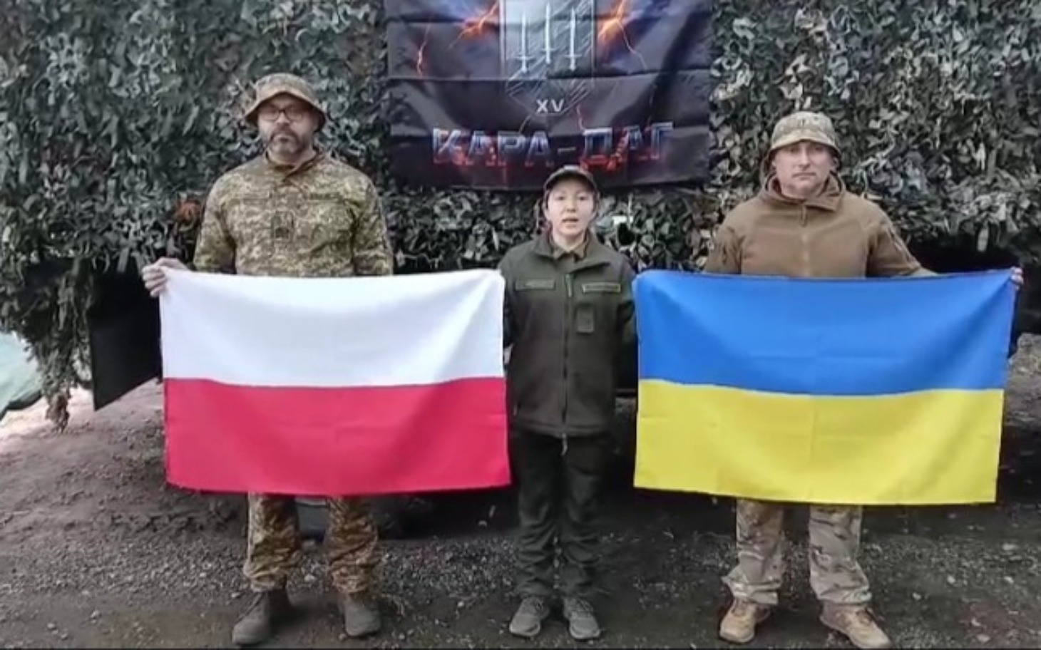 
        Trzy osoby trzymają flagi Polski i Ukrainy.
    