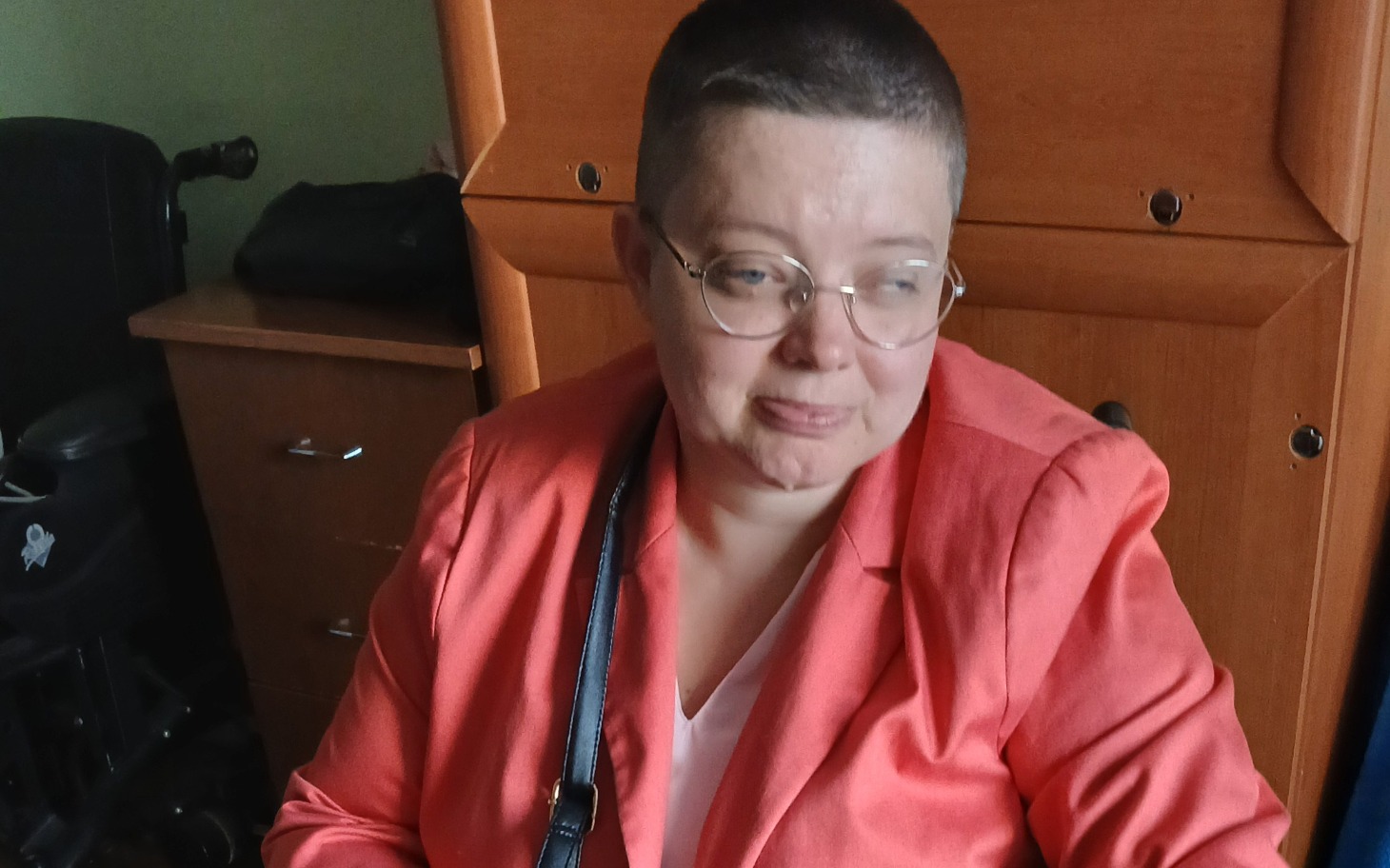 
        Kobieta w różowej marynarce, wygląda na zamyśloną.
    