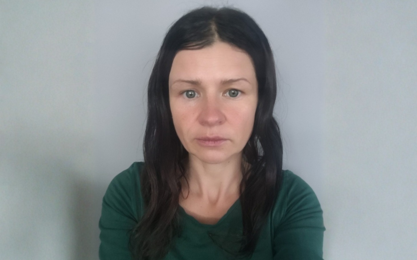 
        Portret kobiety z długimi włosami w zielonej bluzce.
    