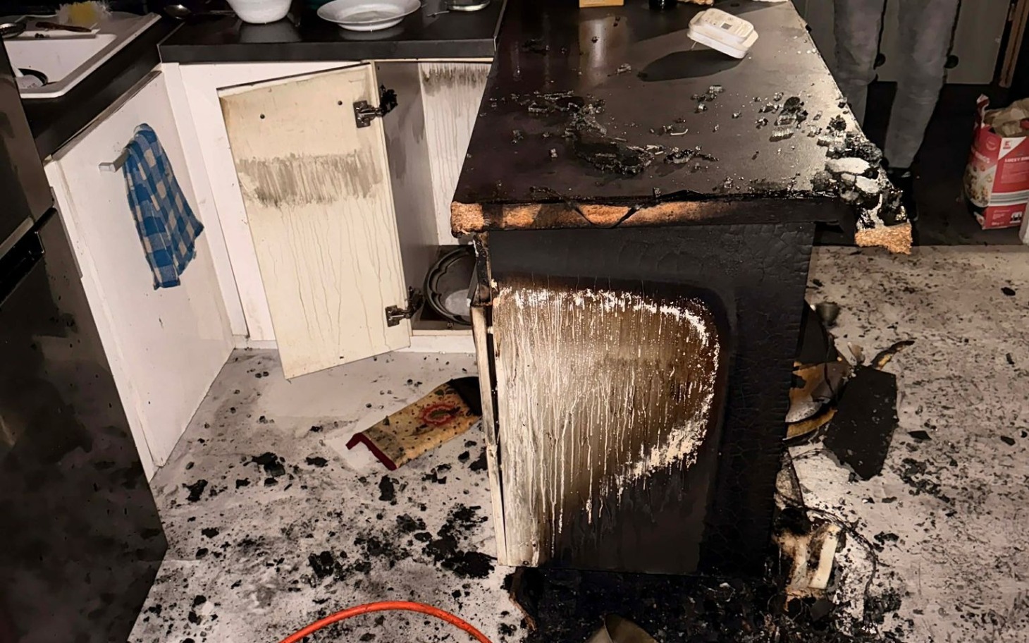 
        Zniszczona kuchnia po pożarze, z bałaganem.
    