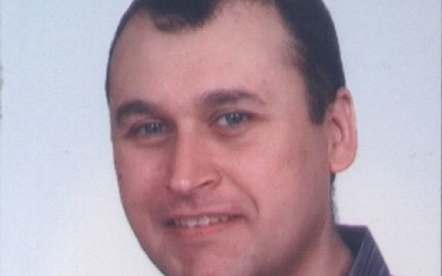 
        Portret mężczyzny z uśmiechem na twarzy.
    