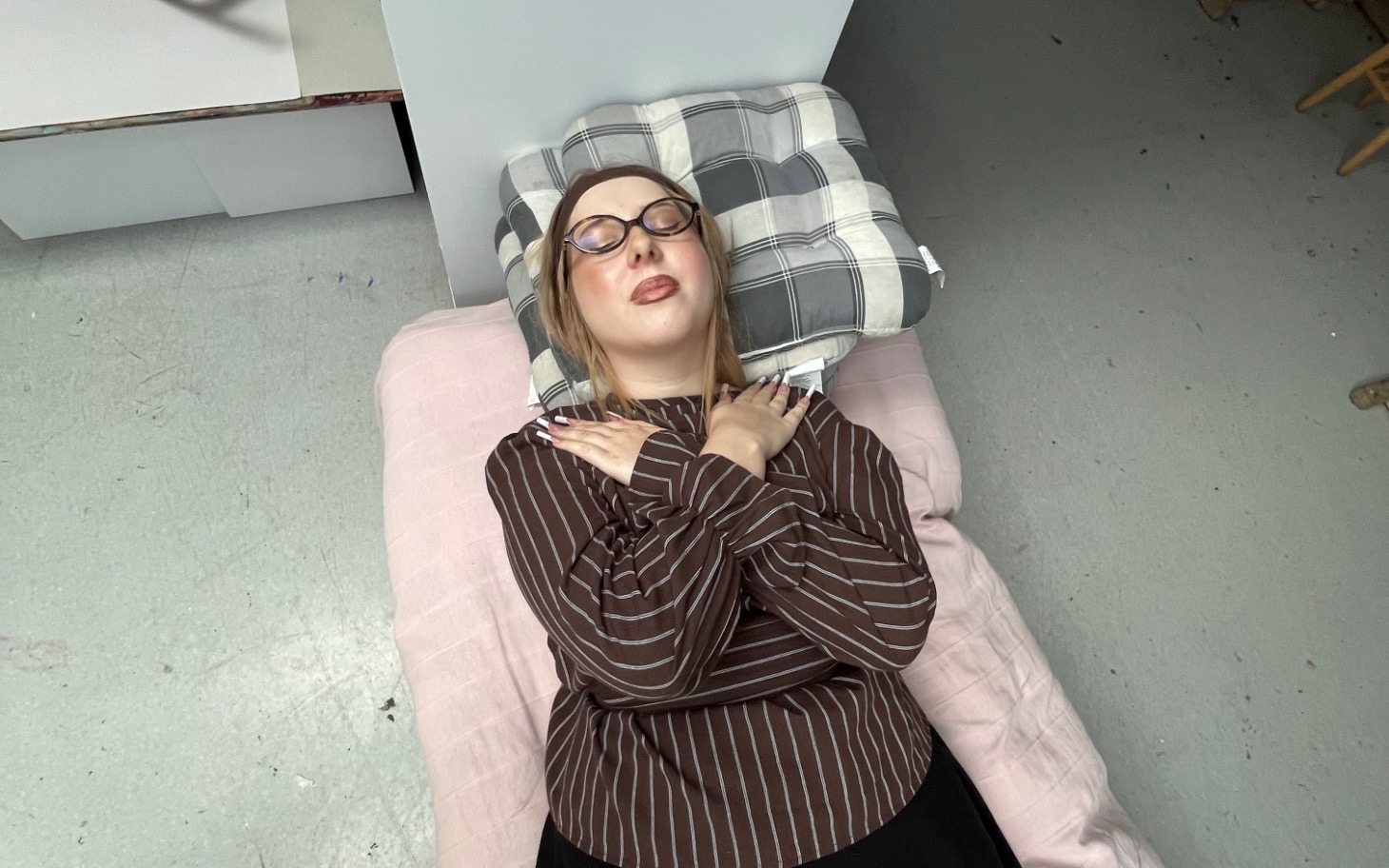 
        Kobieta leżąca na poduszce, z zamkniętymi oczami.
    