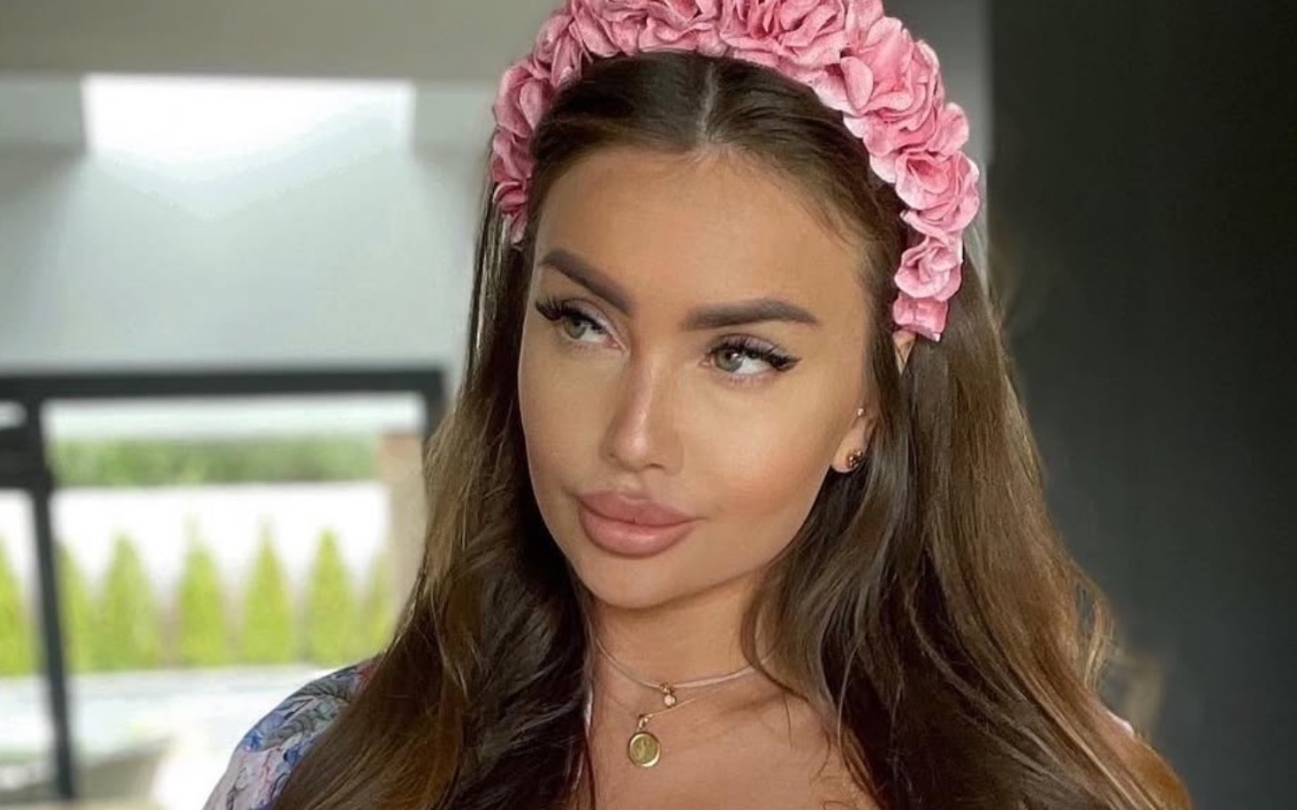 
        Młoda kobieta z różowym diademem, patrząca w dal.
    