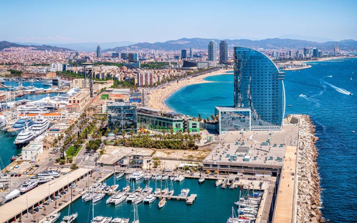 
        Widok na plażę i nowoczesne budynki nad morzem.
    