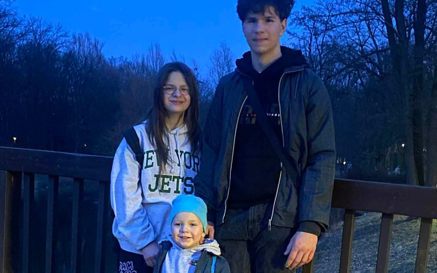 
        Rodzina pozująca na moście w wieczornym świetle.
    