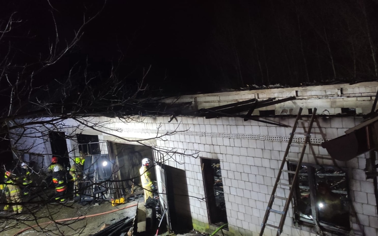 
        Strażacy pracujący przy gaszeniu pożaru budynku.
    