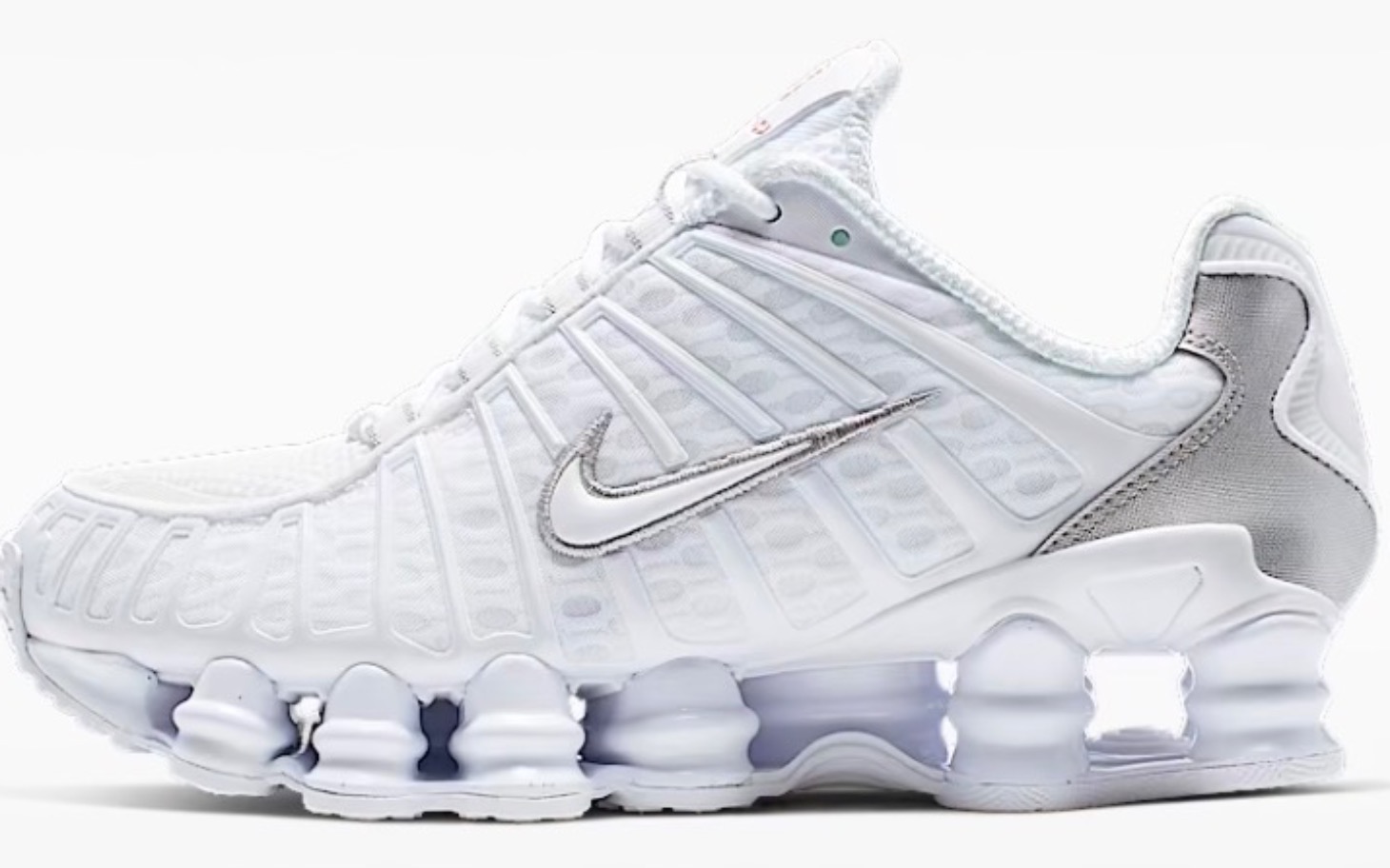 
        Białe buty sportowe Nike z metalicznym wykończeniem.
    