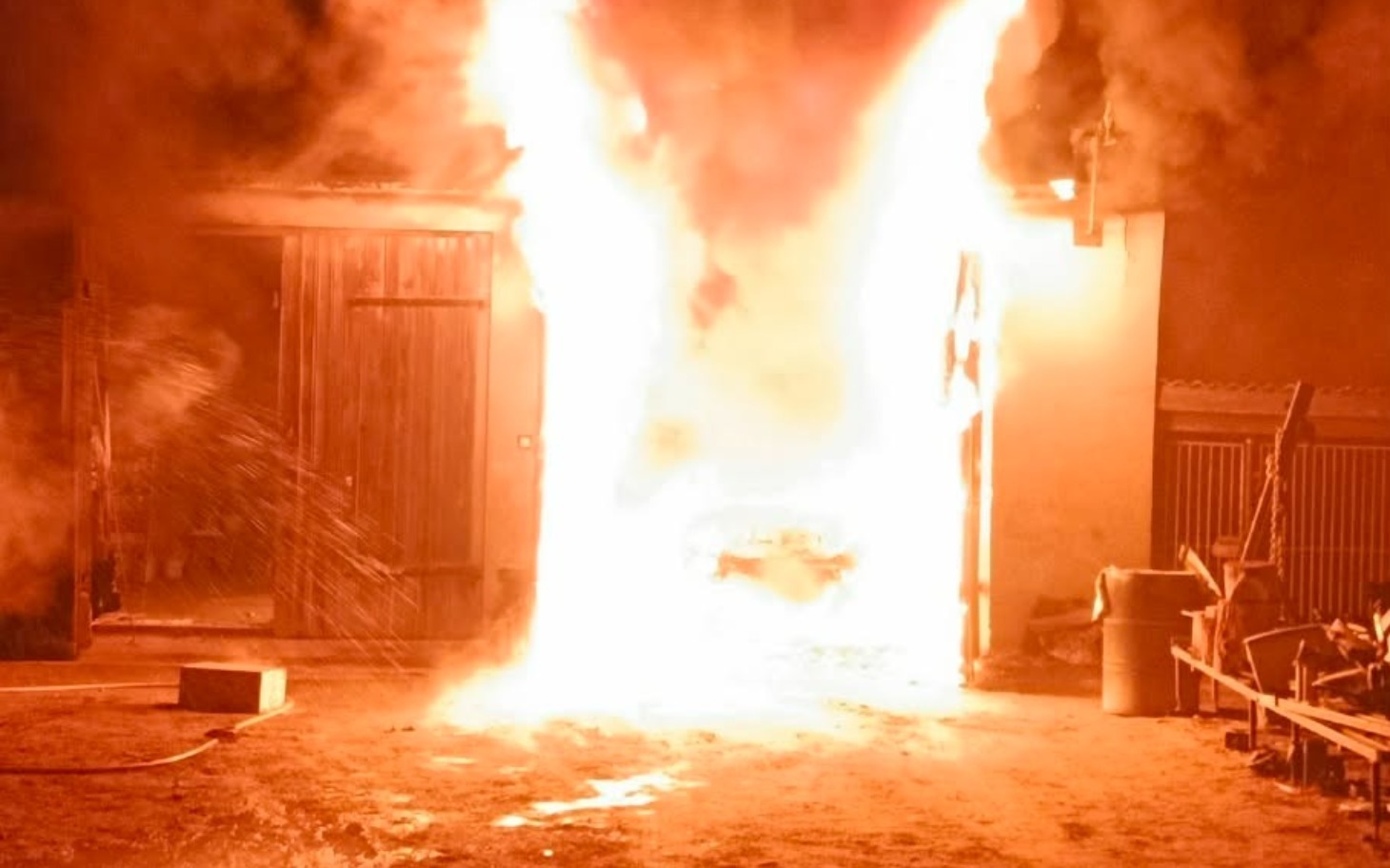 
        Pożar w budynku, ogień wydobywający się z drzwi.
    