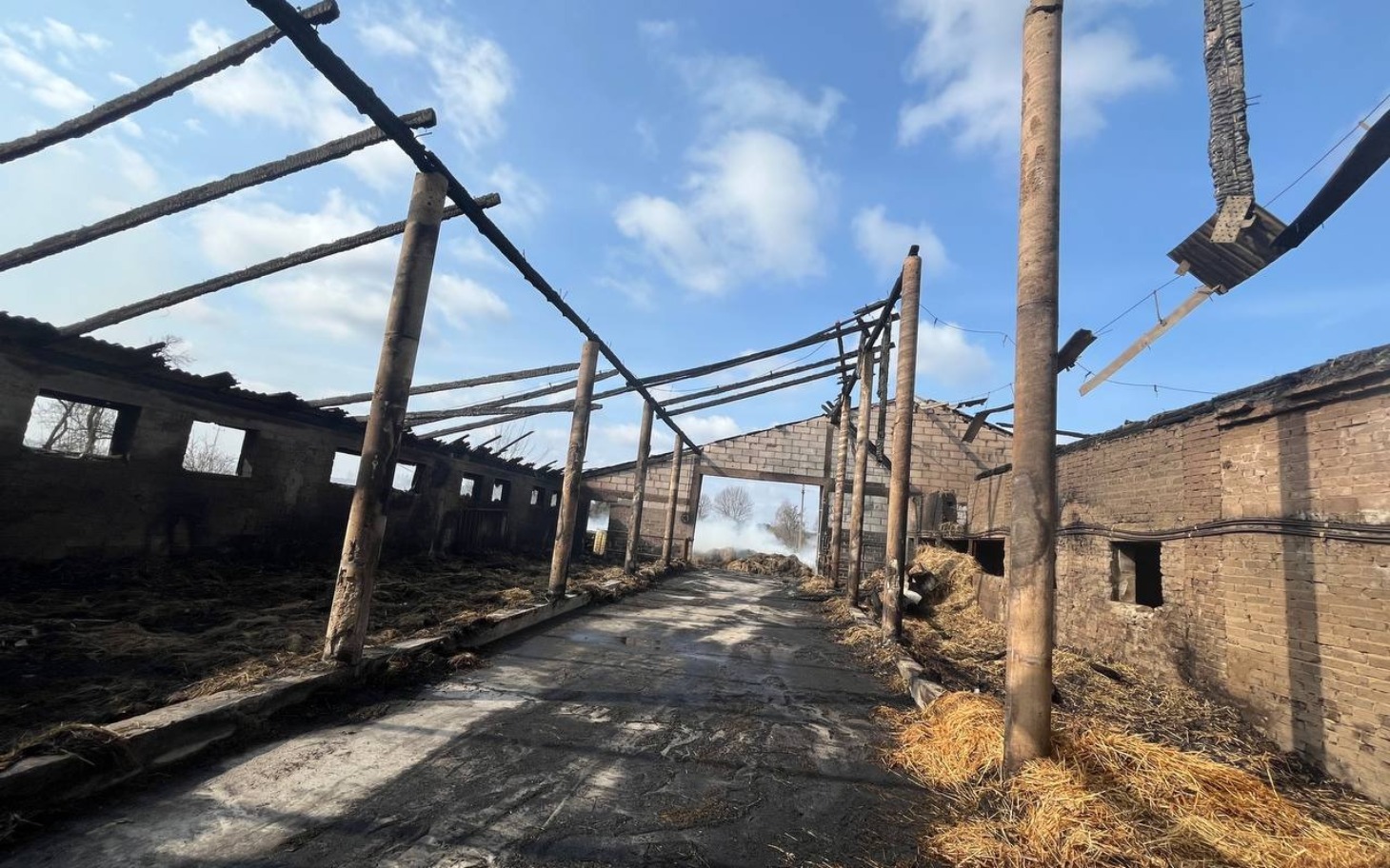 Zniszczony budynek po pożarze, z widocznymi drewnianymi belkami.