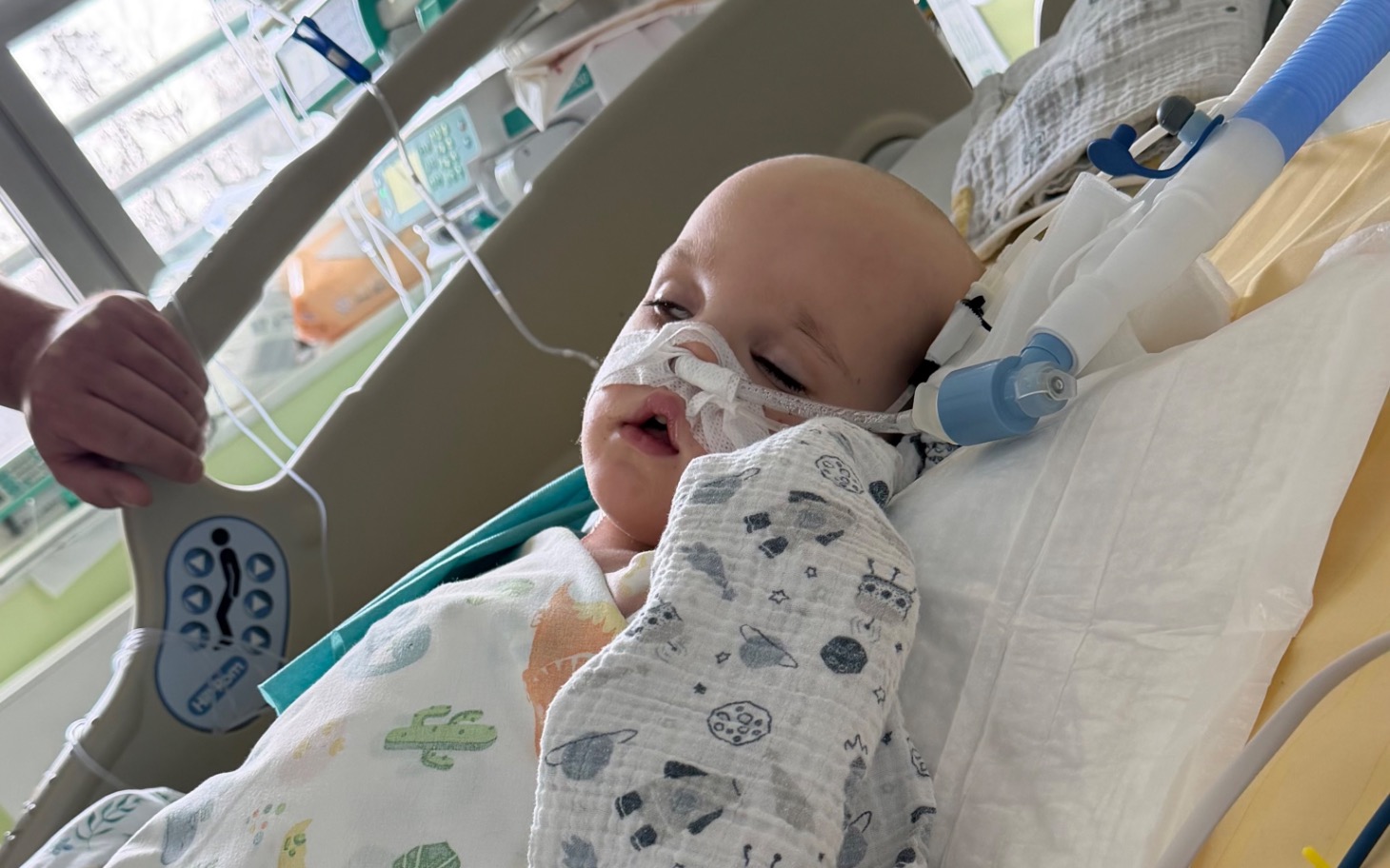 
        Chłopiec w szpitalu, z rurką tlenową i smutnym wyrazem twarzy.
    