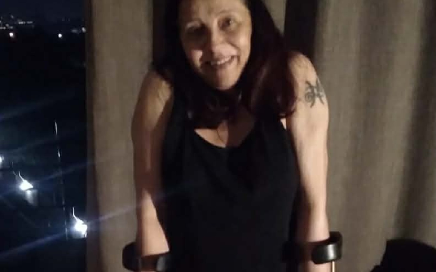 
        Kobieta uśmiechająca się, trzymająca się kul.
    