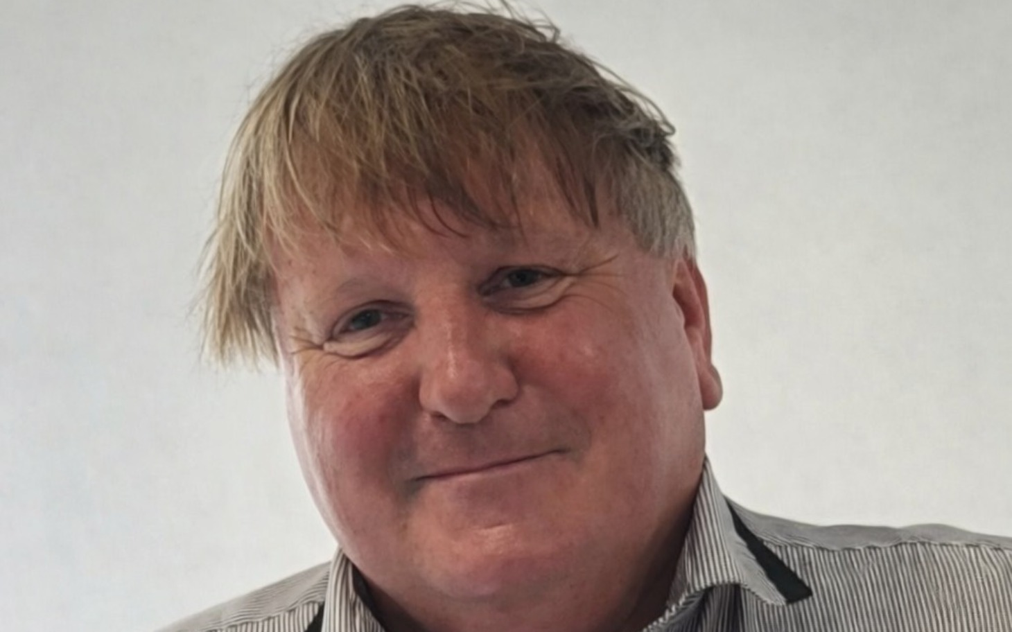 
        Mężczyzna z uśmiechem na twarzy.
    