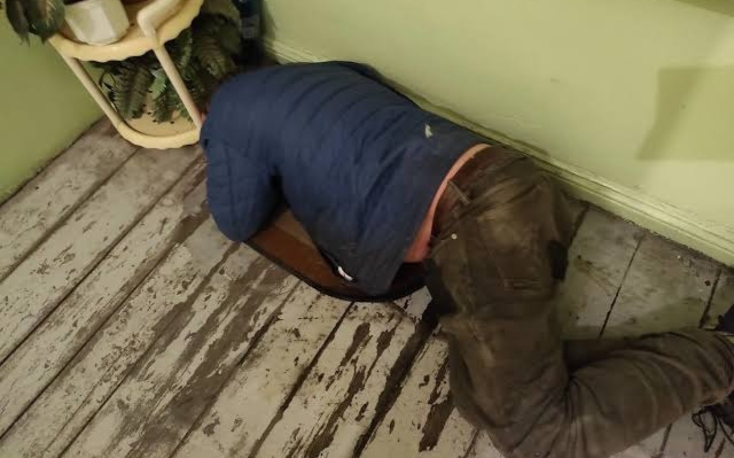 
        Mężczyzna leżący na podłodze, z głową w poduszce.
    